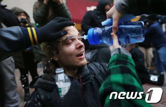 [사진] 물로 눈 씻어내는 反트럼프 시위자