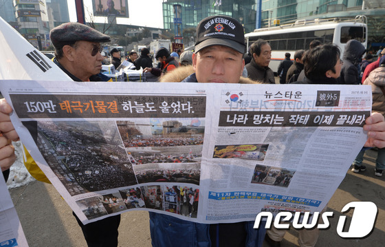 '탄핵기각' 신문 든 보수단체 회원