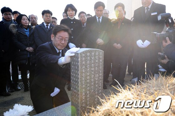 본문 이미지 - 이재명 대통령(당시 성남시장)이 31일 오후 광주 북구 운정동 국립5·18민주묘지에서 참배를 마친 뒤 윤상원 열사 묘역을 찾아 묘비를 어루만지고 있다. 2017.1.31/뉴스1 