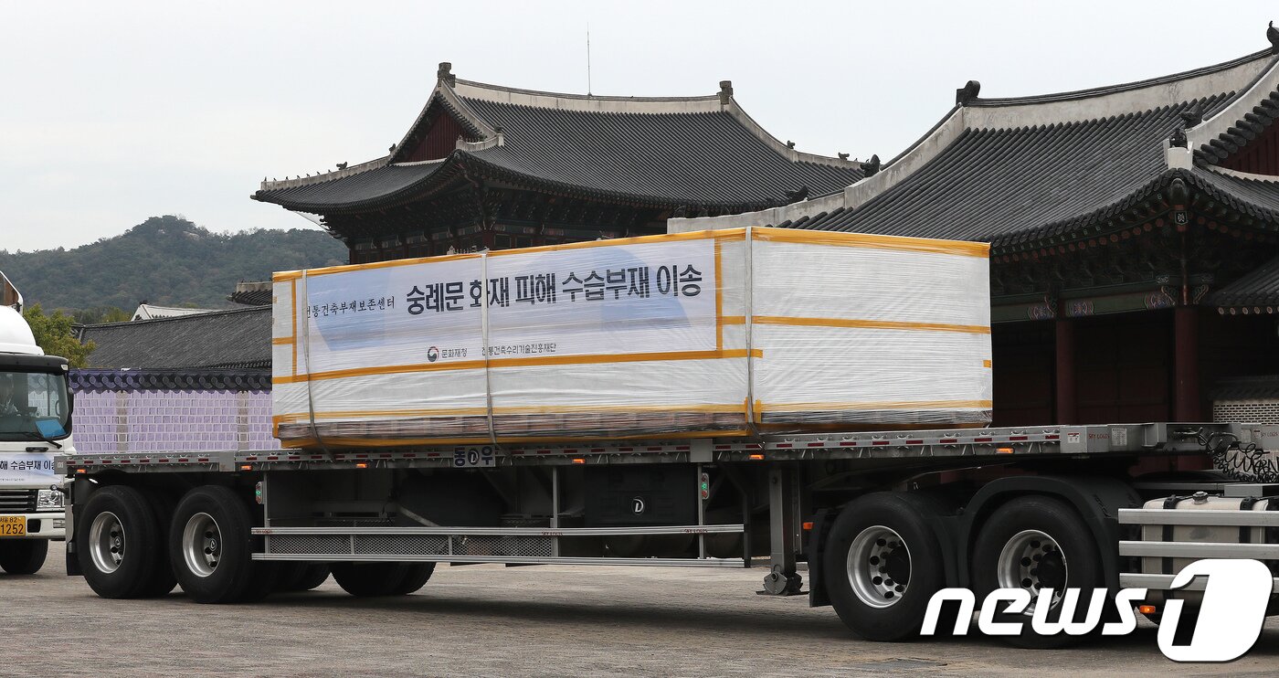 본문 이미지 - 경복궁 창고에 임시로 보관하고 있던 숭례문 수습 부재를 실은 무진동차량이 서울 경복궁에서 파주 전통건축부재보존센터로 출발하는 모습. 2017.10.18/뉴스1 ⓒ News1