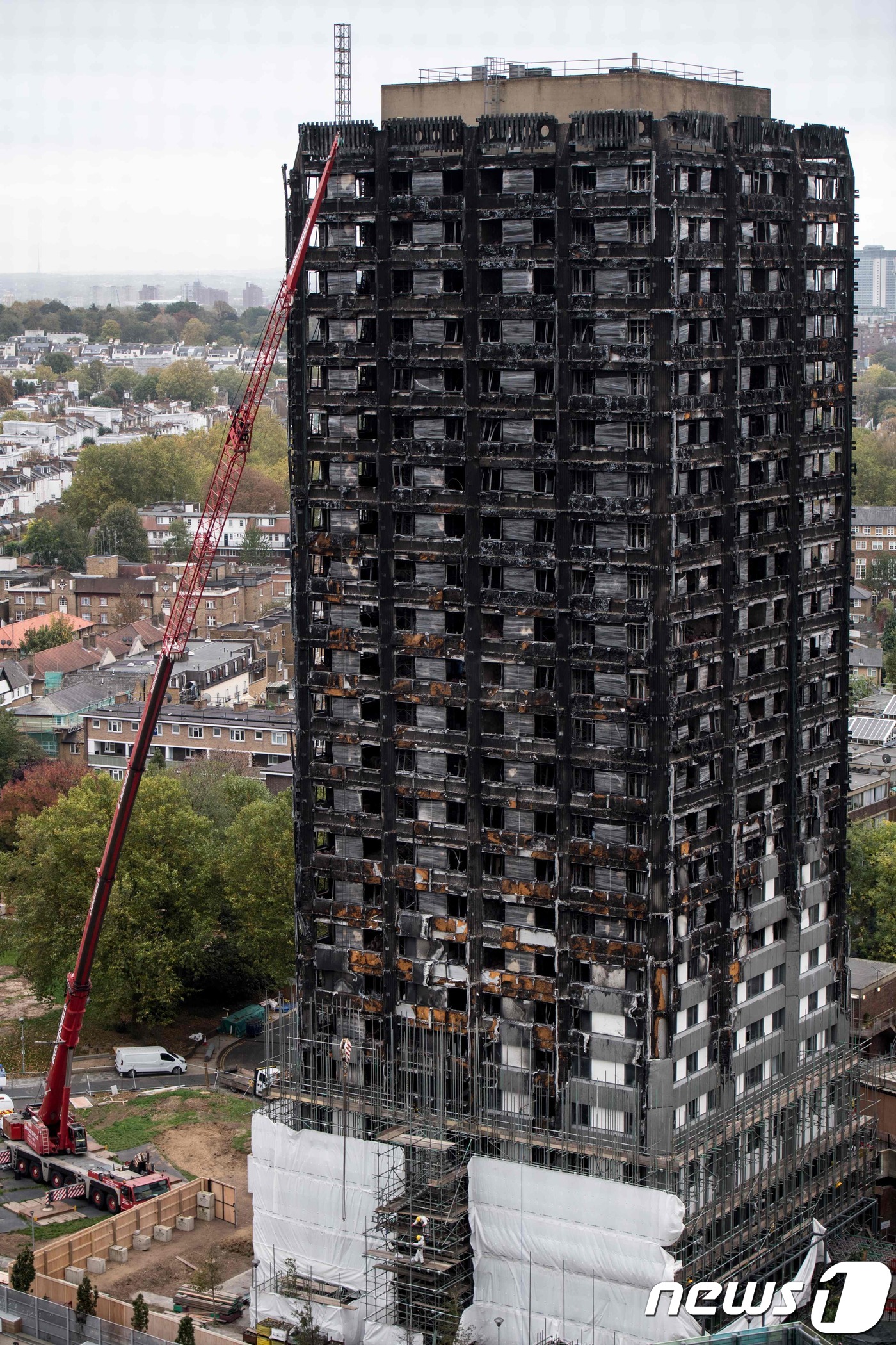 (런던 AFP=뉴스1) 우동명 기자 = 17일(현지시간) 최소 80명이 숨진 화재가 발생한 런던 그렌펠타워의 하층부에 덮개로 씌워진 비계가 보인다. 지난 6월 14일 발생한 그렌펠 …