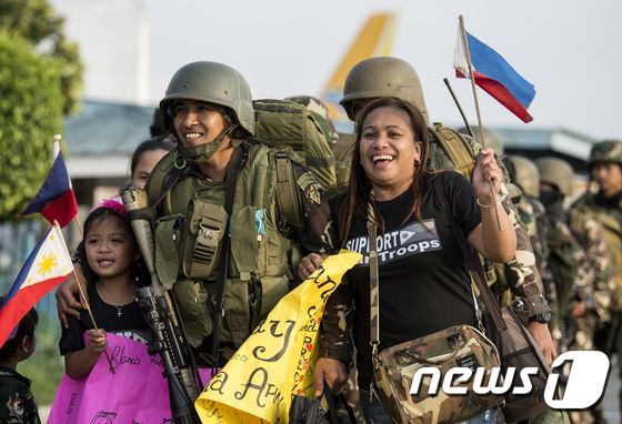 테러리스트와의 전투를 마치고 마닐라로 돌아온 필리핀 군을 가족들이 환영하고 있다. 필리핀 국방부는 23일(현지시간) 지난 5개월간 진행된 마라위 대(對) IS 전투가 종료됐다고 했다. © AFP=뉴스1