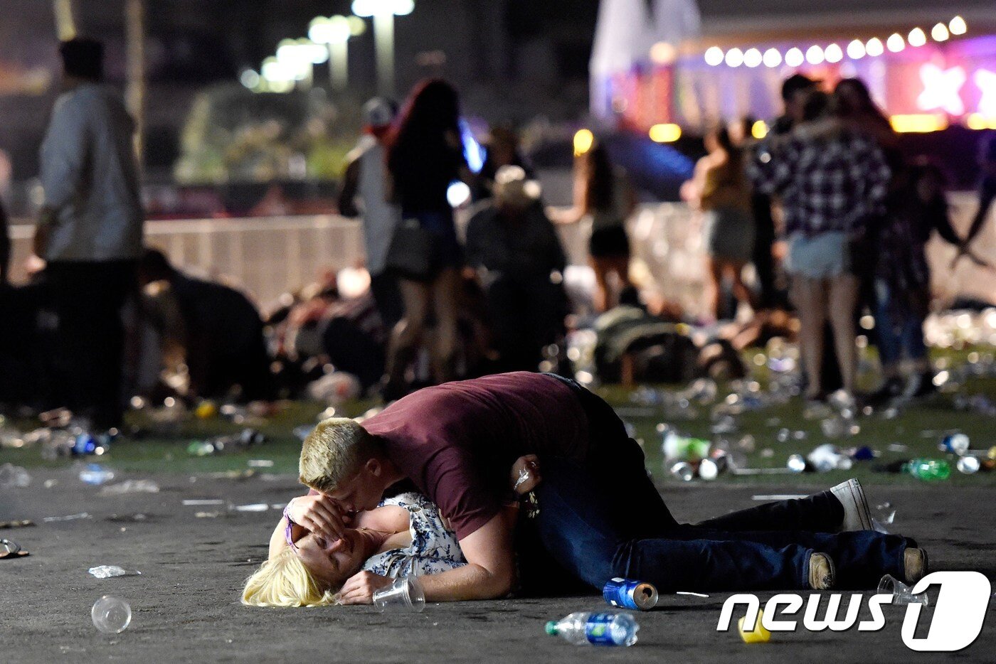 본문 이미지 - 1일 미 라스베이거스 중심가(라스베이거스 스트립)에서 열린 '루트 91 하비스트' 컨트리 음악 야외 콘서트장에서 무차별 총기난사가 벌어졌다. 총알이 쏟아지는 상황에서 한 남성이 자신의 몸으로 여성을 보호했다. ⓒ AFP=뉴스1