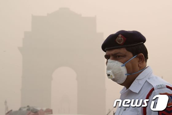 인도 의 한 경찰이 뉴델리에 있는 인디아 게이트 근처에서 마스크를 쓰고 근무하고 있다. © AFP=뉴스1 © News1 