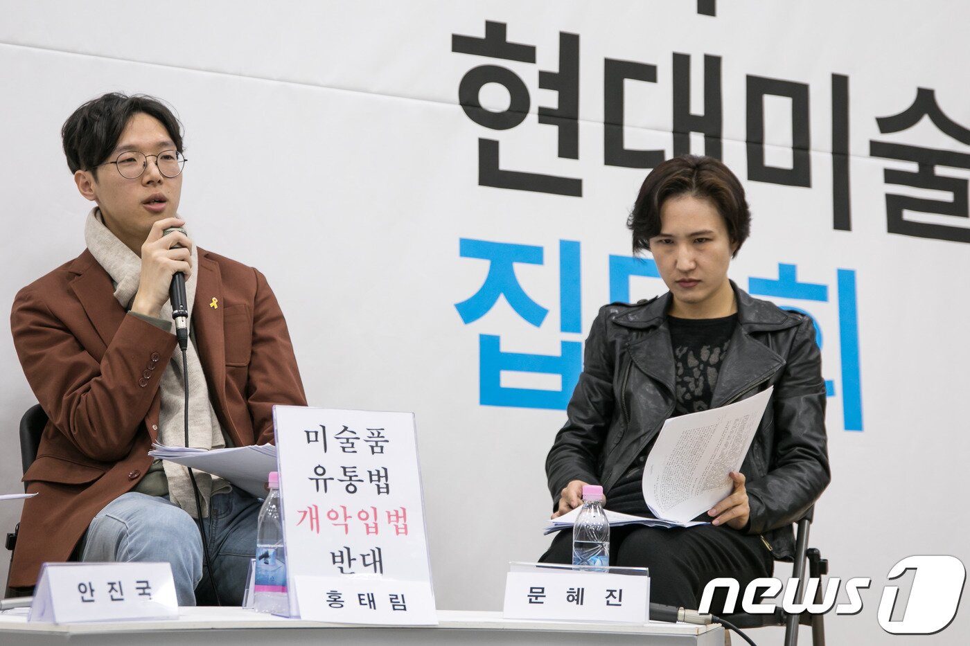 본문 이미지 - 홍태림 미술평론가(왼쪽)가 24일 서울 중구 서소문동 서울시립미술관 서소문본관 세마홀에서 열린 한국 현대미술 비평 집담회 도중 '미술품 유통법 개악입법 반대' 퍼포먼스를 펼치고 있다. 2017.11.24/뉴스1 ⓒ News1 박정환 기자