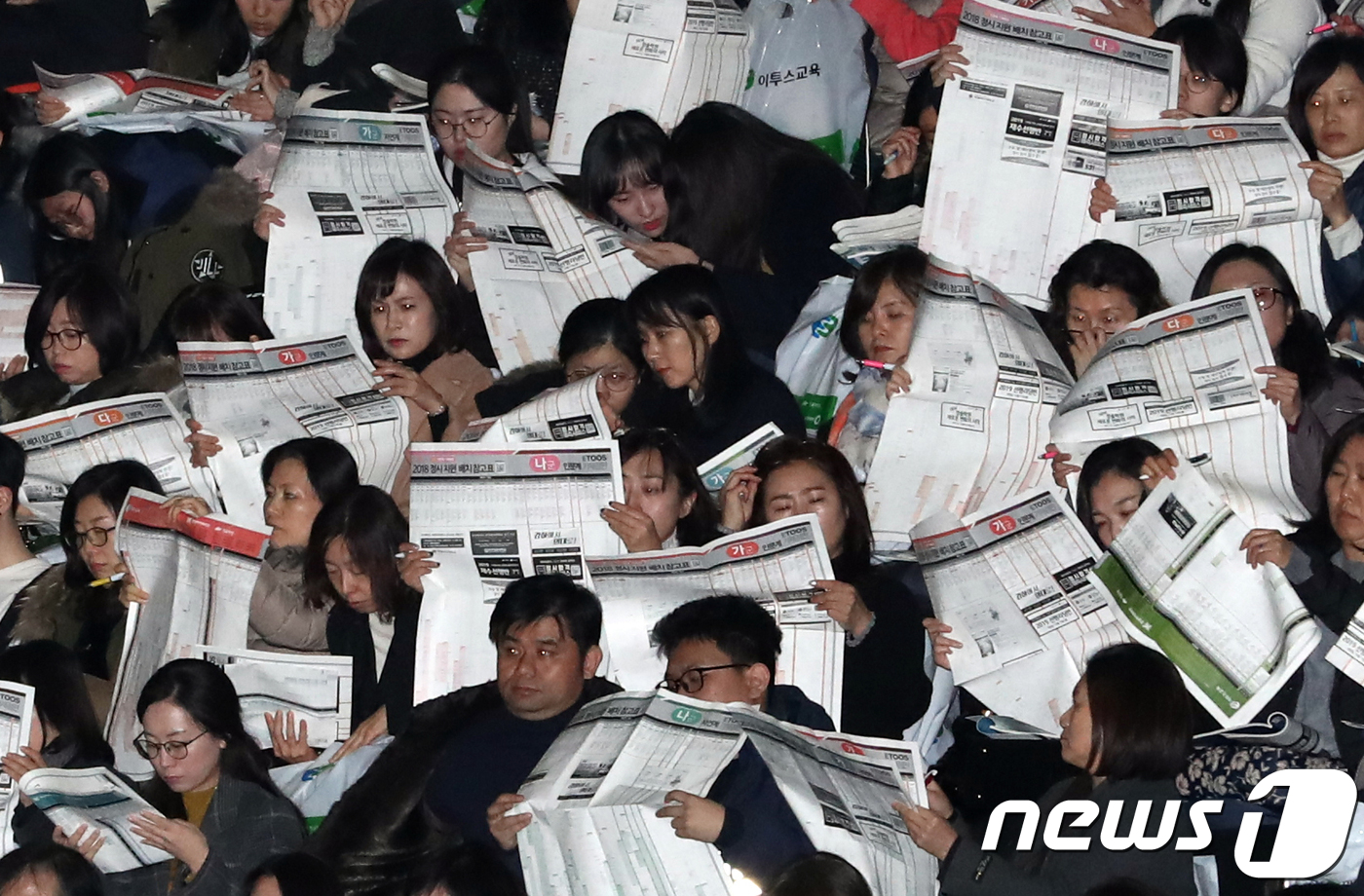 (서울=뉴스1) 황기선 기자 = 수험생과 학부모들이 25일 서울 성동구 한양대학교 체육관에서 열린 '이투스 2018학년도 수능가채점분석설명회'에서 입시 자료를 보며 전문가의 입시전 …