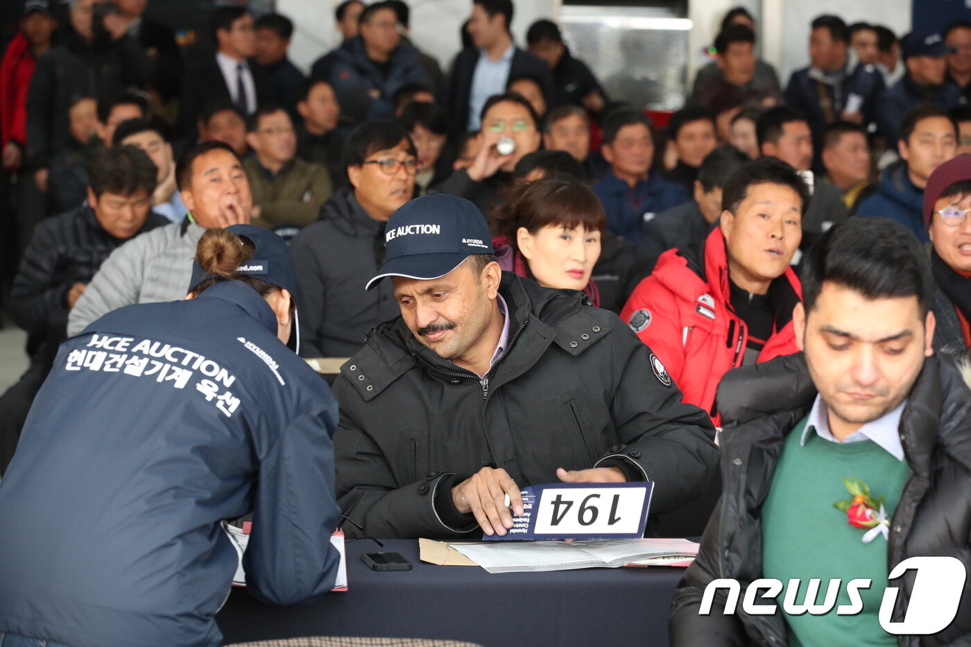 본문 이미지 - 충북 음성 소재 현대건설기계 음성공장에서 중고 굴삭기 경매인 '현대건설기계 옥션'이 진행됐다. 사진은 경매낙찰자가 가계약서에 서명하는 모습. 2017.11.26/ ⓒ News1