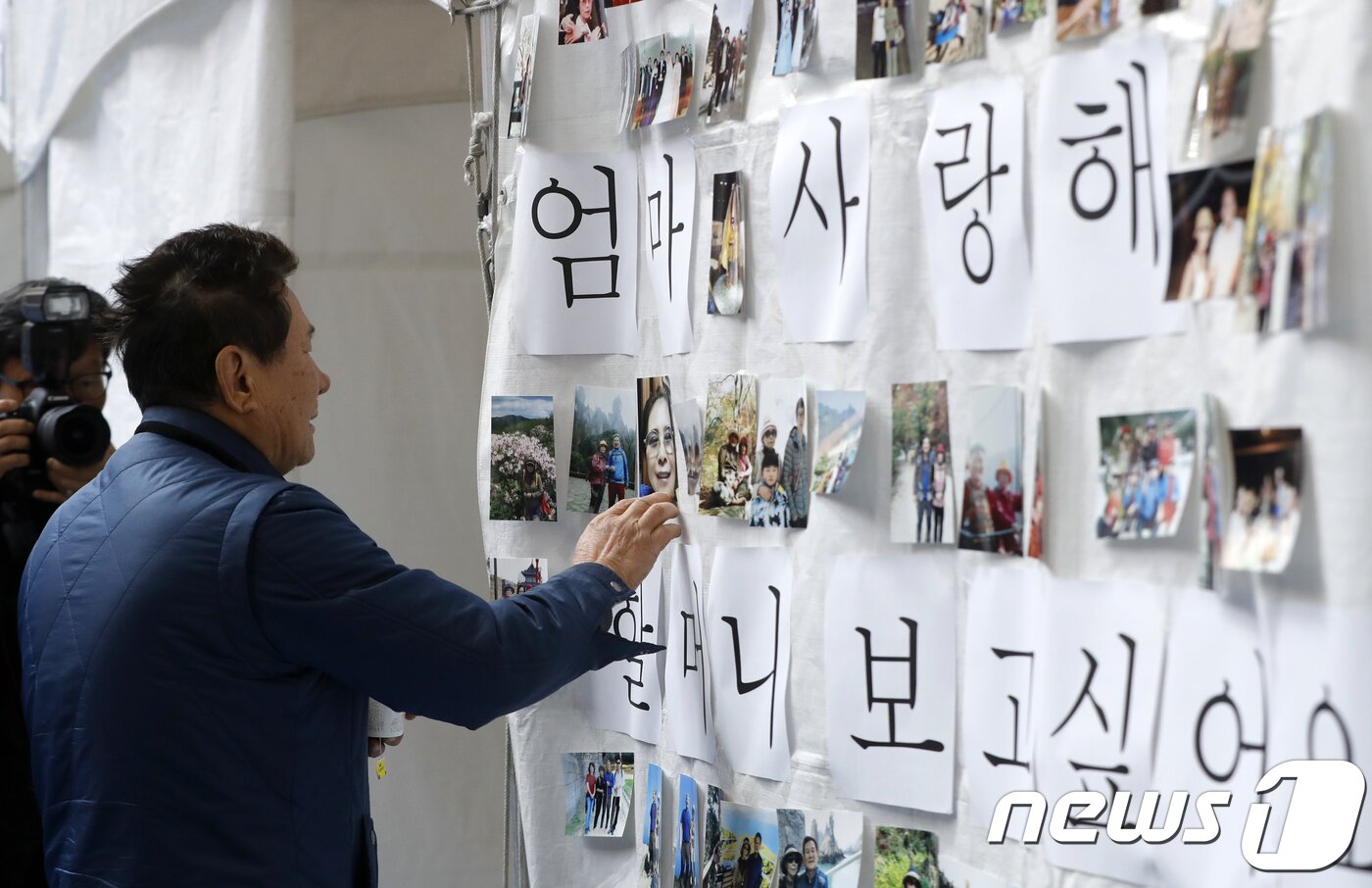 본문 이미지 - 25일 오전 충북 제천체육관에 마련된 노블 휘트니스스파 화재 참사 희생자 합동분향소에서 고 장경자씨 남편 김인동씨가 사진을 어루만지고 있다. 2017.12.25/뉴스1 ⓒ News1 안은나 기자