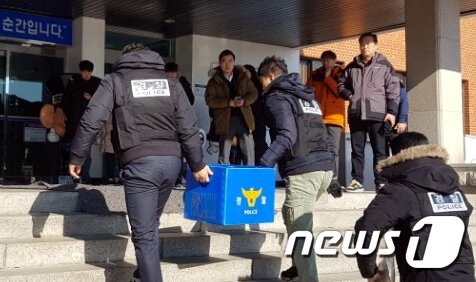 본문 이미지 - 제천 스포츠센터 화재 참사와 관련해 경찰이 지난해 12월25일 건물주 이모씨(53)의 자택과 차량, 휴대전화 등에 대한 압수수색을 벌인 뒤 압수품을 경찰서로 들고 들어가고 있다. 2017.12.25/뉴스1 ⓒ News1 박태성 기자