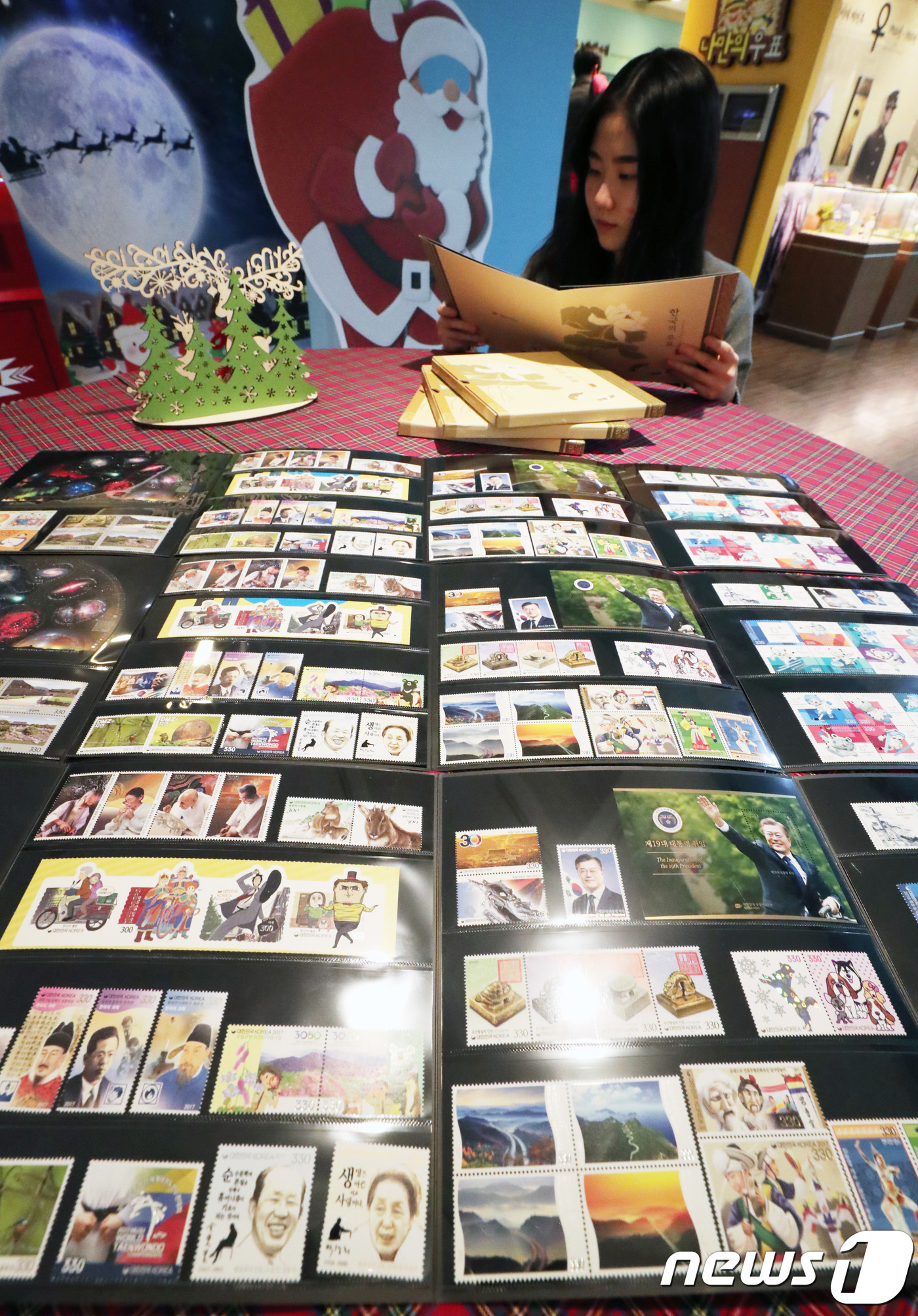 (서울=뉴스1) 이재명 기자 = 29일 오후 서울 중구 서울중앙우체국에서 한 시민이 ‘2017년 한국의 우표책과 우표첩’을 살펴보고 있다. 우정사업본부는 이날부터 올해 국내에서 발 …