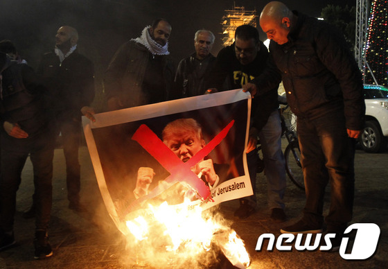 팔레스타인 주민들이 5일(현지시간) 도널드 트럼프 미국 대통령의 예루살렘 수도 인정 예고에 반발해 트럼프의 사진을 불에 태우고 있다. © AFP=뉴스1