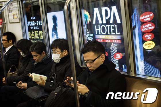 본문 이미지 - 일본 도쿄를 달리는 지하철 뒤로 APA 호텔 체인 광고판이 보인다.  ⓒ AFP=뉴스1
