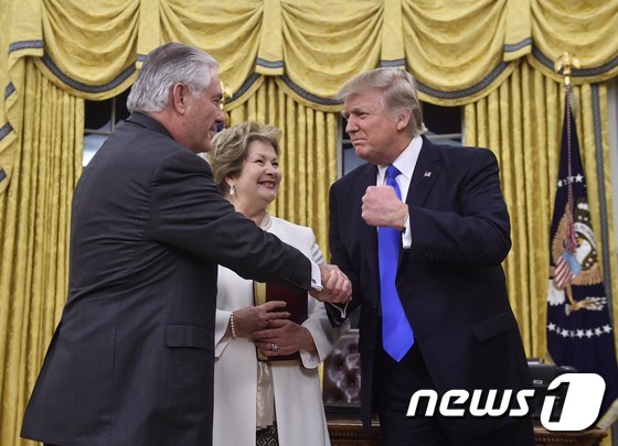 도널드 트럼프 대통령(오른쪽)과 악수하는 렉스 틸러슨 국무장관. 가운데는 틸러슨 장관의 부인 렌다 세인트 클레어. © AFP=뉴스1