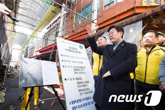 (성남=뉴스1) = 이재명 성남시장이 청년배당 체험행사에 나선 20일 오전 경기도 성남시 중원구 상대원시장에서 비가림시설 공사현장을 살펴보고 있다. (성남시 제공) 2017.2.2 …