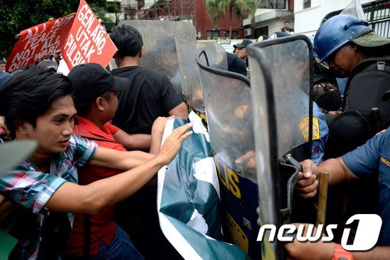 필리핀 활동가들이 25일 마닐라 경찰본부에서 로드리고 두테르테 대통령의 마약과의 전쟁에 항의하는 시위 도중 경찰과 충돌하고 있다. © AFP=뉴스1