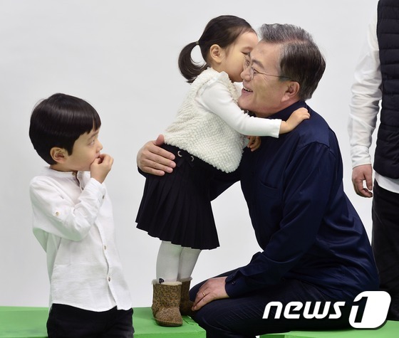 (서울=뉴스1) 민경석 기자 = 문재인 더불어민주당 전 대표가 26일 오후 서울 강남구의 한 스튜디오에서 국민경선 참여를 독려하는 캠페인 홍보영상을 촬영하던 중 어린이를 안아주고 …