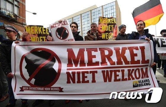 본문 이미지 - 지난해 12월 벨기에 브뤼셀에서 한 극우단체가 앙겔라 메르켈 독일 총리의 난민 정책 반대하는 시위를 펼치고 있다.  ⓒ AFP=뉴스1