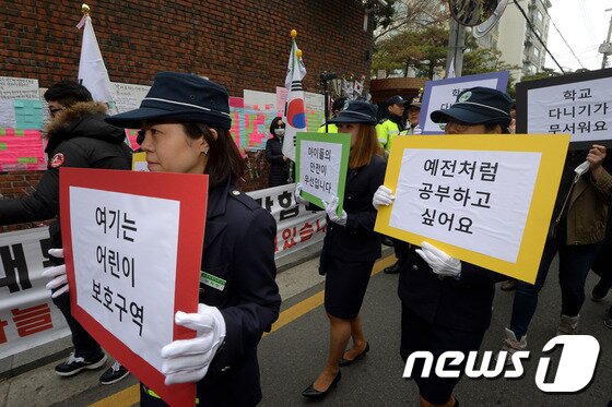 본문 이미지 - 박근혜 전 대통령이 자택으로 돌아온 지 9일째인 20일 서울 강남구 삼성동 박 전 대통령 자택 앞에서 삼릉초등학교 녹색어머니회 회원들이 손팻말을 들고 행진하고 있다. 2017.3.20/뉴스1 ⓒ News1 황기선 기자
