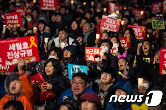 본문 이미지 - 25일 서울 광화문광장에서 열린 '21차 범국민행동의 날' 촛불집회에 참석한 시민들이 박근혜 전 대통령의 구속과 세월호 진상규명을 촉구하며 촛불을 들고 있다. 2017.3.25/뉴스1 ⓒ News1 유승관 기자