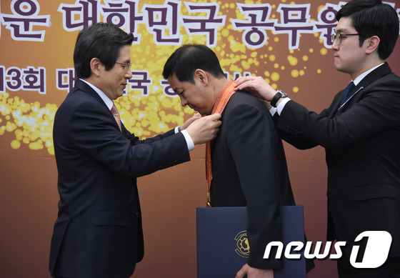 (서울=뉴스1) = 황교안 대통령 권한대행 국무총리가 7일 서울 중구 한국프레스센터에서 열린 '대한민국 공무원상 시상식'에서 구윤철 기획재정부 예산총괄심의관에게 홍조근정훈장을 수여 …