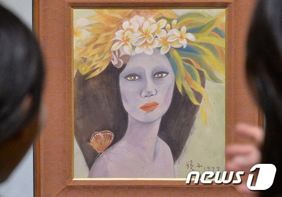 본문 이미지 - 18일 경기도 과천 국립현대미술관에서 관계자가 고&#40;故&#41; 천경자&#40;1924∼2015&#41; 화백의 작품인지를 놓고 논란이 계속되는 &#39;미인도&#39;를 바라보고 있다. 2017.4.18/뉴스1 ⓒ News1 김명섭 기자