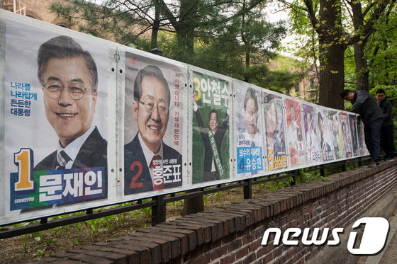(서울=뉴스1) 유승관 기자 = 선관위 직원들이 20일 서울 종로구 동숭동의 한 거리에 제19대 대통령선거 선거벽보를 부착하고 있다.15명의 후보자가 출마해 10m가 넘는 사상 최 …