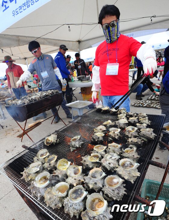 본문 이미지 - 21일 제주시 우도에서 개막한 제9회 우도소라축제에서 축제 관계자들이 소라를 굽고 있다.2017.4.21/뉴스1 ⓒ News1 이석형 기자