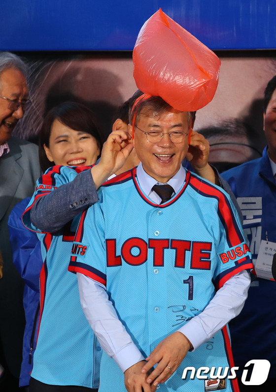 (부산=뉴스1) 허경 기자 = 더불어민주당 문재인 대선후보가 22일 오후 부산 서면 젊음의 거리에서 열린 집중 유세에서 전 롯데 자이언츠의 박정태 선수에게 유니폼을 전달받은 뒤 응 …