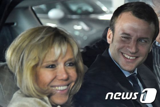 본문 이미지 - 프랑스 대선 1차 투표에서 최다 득표로 결선에 진출하게 된 중도정당 앙마르슈(전진)의 에마뉘엘 마크롱 후보(오른쪽)와 아내인 브리지트 ⓒ AFP=뉴스1