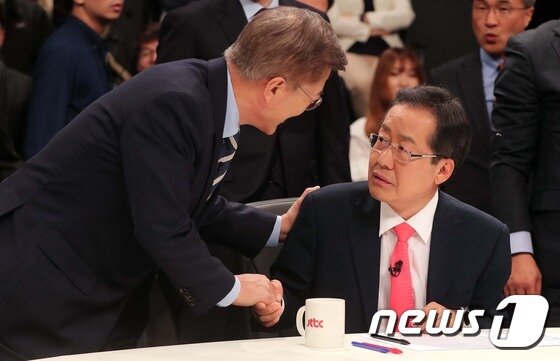 본문 이미지 - 2017년 4월 25일 당시 문재인 더불어민주당 대선후보(왼쪽)와 홍준표 자유한국당 후보가 경기도 고양시 빛마루 방송지원센터에서 열린 중앙일보-JTBC-한국정치학회 공동주최 2017 대통령 후보 초청 토론회 전 악수하고 있다. ⓒ News1 국회사진취재단