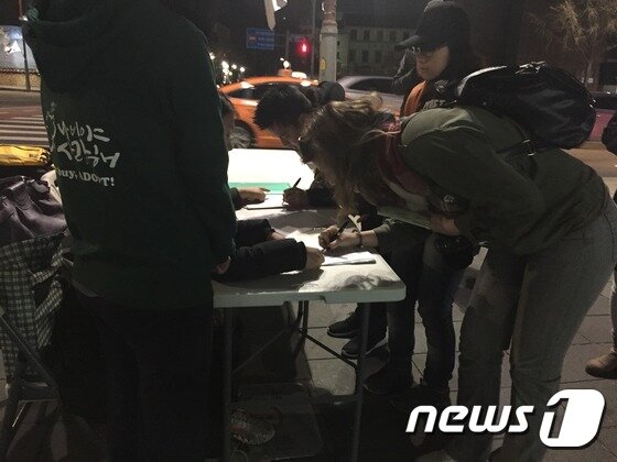 본문 이미지 - 시민들이 개·고양이 식용 금지 특별법 제정을 위한 서명에 동참하고 있다. ⓒ News1