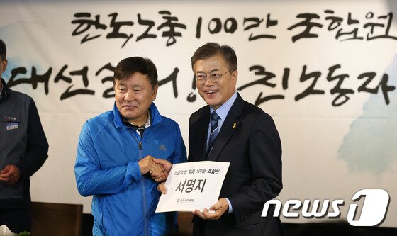 본문 이미지 - 문재인 더불어민주당 대통령후보가 &#39;노동절&#39;인 1일 여의도 한국노총에서 열린 정책연대 협약식에 참석, &#39;노동악법 철폐&#39; 100만 조합원 서명지를 전달받고 있다. 2017.5.1/뉴스1 ⓒ News1 허경 기자