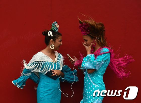 (AFP=뉴스1) 김윤정 기자 = 30일(현지시간) 스페인 세비야에서 4월의 축제(페리아 데 아브릴)에 참가한 두 소녀가 세비야인 전통 의상을 입고 이야기를 나누고 있다. 1847 …