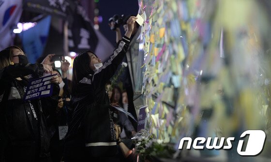 본문 이미지 - 강남역 여성살해사건 1주기인 17일 오후 서울 강남구 신논현역을 출발한 범페미네트워크 '우리의 두려움은 용기가 되어 돌아왔다' 추모문화제 참가자들이 강남역 10번출구에 추모 포스트잇을 붙이고 있다.2017.5.17/뉴스1 ⓒ News1 안은나 기자