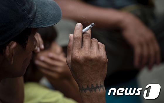 필리핀 남성이 담배를 피우고 있다 © AFP=뉴스1