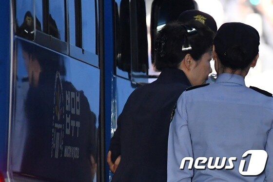 뇌물혐의 등으로 구속기소 된 박근혜 전 대통령이 23일 오전 서울 서초동 서울중앙지법에서 열리는 첫 재판에 출석하기 위해 호송차에서 내려 법정으로 향하고 있다. 박 전 대통령은 지난 3월 31일 서울구치소에 수감된지 53일 만에 검은색 사복과 올림머리를 하고 모습을 드러냈다.2017.5.23/뉴스1 © News1 유승관 기자