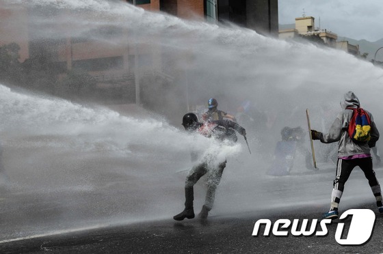 [사진] 거대한 물대포에 맞서는 베네수엘라 시위대