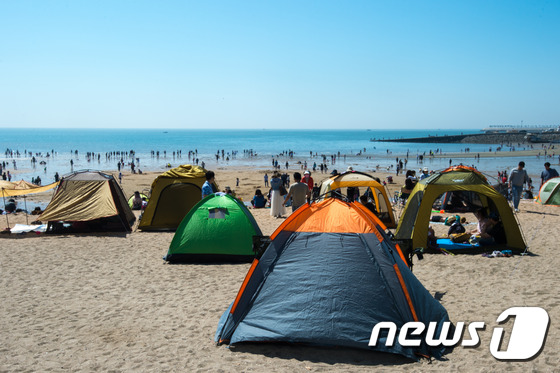 (인천=뉴스1) 성동훈 기자 = 서울 낮 최고기온이 30도를 넘나드는 등 전국이 20~30도 수준의 초여름 날씨를 보이고 있는 3일 오후 인천 을왕리 해수욕장에서 시민들이 무더위를 …