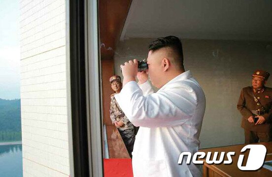 본문 이미지 - 김정은 북한 노동당 위원장이 쌍안경을 들고 새로 개발한 정밀 조종유도체계를 도입한 탄도미사일 시험발사를  지켜보고 있다. 오른손에 담배를 쥐고 있다. (노동신문) 2017.5.30/뉴스1 ⓒ News1 임세영 기자
