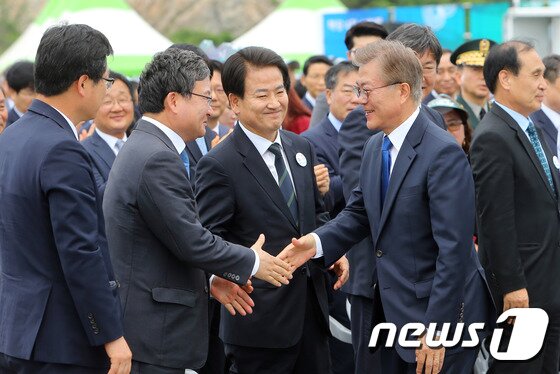 본문 이미지 - 문재인 전 대통령이 지난 2017년 전북 군산시 새만금 신시광장에서 열린 제22회 바다의 날 기념식을 마치고 전북지역 국회의원들과 인사를 하고 있는 모습.2017.5.31/뉴스1 ⓒ News1 문요한 기자