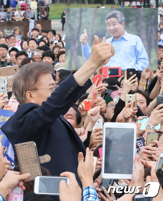 (고양=뉴스1) 허경 기자 = 문재인 더불어민주당 대선 후보가 4일 경기 고양시 일산동구 문화광장에서 열린 집중유세에서 지지자들의 환호에 두 팔 벌려 화답하고 있다. 뒤로는 노무현 …