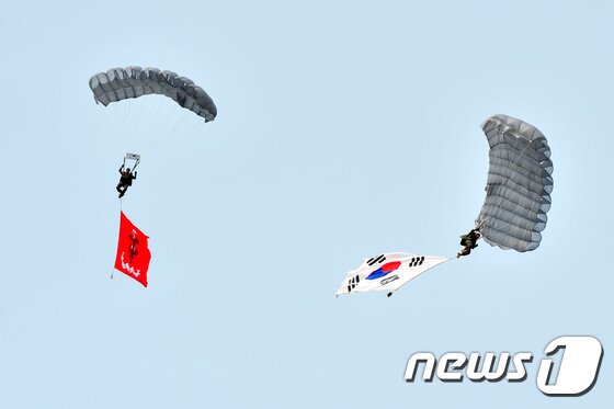 본문 이미지 - 10일 오후 해병대 1사단 특수수색대요원들이 2017포항해병문화축제가 열린 형산강 일원에서 태극기와 해병대기를 펼치고 고공강하 시범을 보이고 있다.2017.6.10/뉴스1 ⓒ News1 최창호 기자