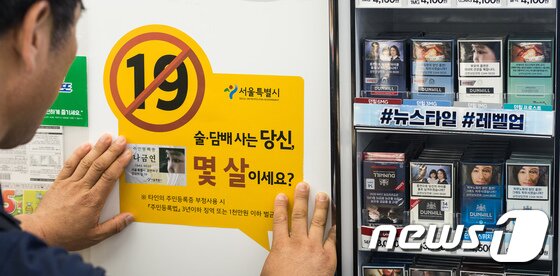 본문 이미지 - 서울시 민생사법경찰단이 16일 서울 종로구 동숭동의 한 편의점에 청소년 대상 술·담배 판매금지 경고문구 스티커를 부착하고 있다. 서울시 건강증진과와 민생사법경찰단은 이날부터 금연단속요원, 흡연제로 네트워크 시민단체와 함께 청소년의 이용이 높은 학교주변 편의점을 대상으로 '술·담배 불법판매 근절 합동 계도'를 실시한다고 밝혔다. 2017.6.16/뉴스1 (자료사진) ⓒ News1 유승관 기자