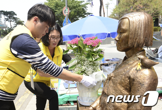(서울=뉴스1) 신웅수 기자 = 17일 오후 서울 종로구 옛 일본대사관 앞에서 성남 평화의 소녀상지킴이 회원들과 성일고등학교 학생들이 평화의 소녀상을 어루만지고 있다.이들은 굴욕적 …