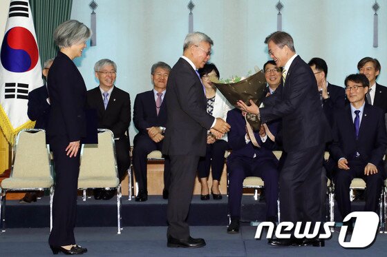 본문 이미지 - 문재인 대통령이 18일 오후 청와대에서 열린 강경화 외교부장관 임명식에서 강 장관의 남편인 이일병 교수에게 꽃다발을 주고 있다.(청와대) 2017.6.18/뉴스1 ⓒ News1 이광호 기자