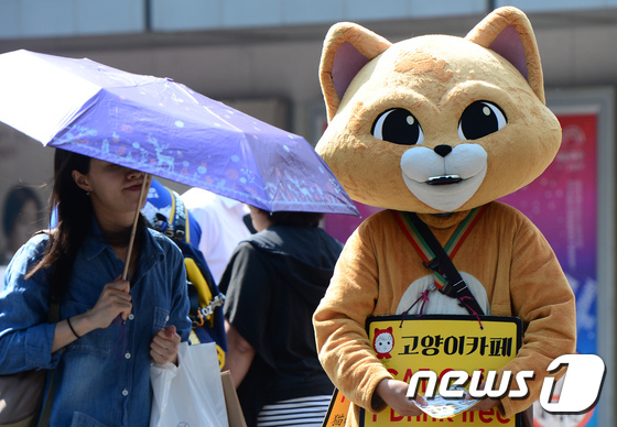 (서울=뉴스1) 박지혜 기자 = 때 이른 무더위가 계속된 21일 오후 서울 중구 명동거리에서 인형 탈을 쓴 알바생이 전단지를 돌리고 있다. 2017.6.21/뉴스1