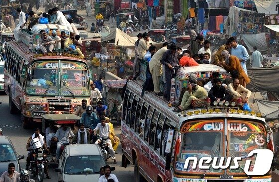 본문 이미지 - 24일(현지시간) 파키스탄 라호르에서 승객들이 가득 찬 버스가 이동하고 있다. 이들은 이슬람 명절을 가족들과 함께 보내기 위해 고향으로 가고있다. ⓒ AFP=뉴스1