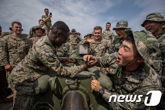 (포항=뉴스1) 최창호 기자 = 29일 경북 포항 수성사격장에서 실시된 한·미 해병대 포병 연합훈련에 참가한 해병대원들이 팔씨름을 하며 전우애를 확인하고 있다.지난 22일부터 30 …