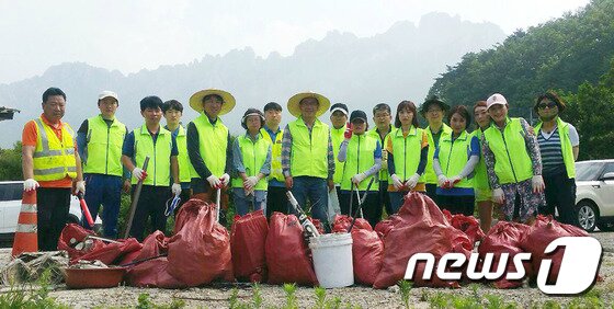 본문 이미지 - 29일 미시령동서관통도로주식회사 관계자들이 미시령옛길 청소봉사를 마치고 기념촬영하고 있다.  (미시령동서관통도로 제공) 2016.6.29/뉴스1 ⓒ News1 고재교 기자
