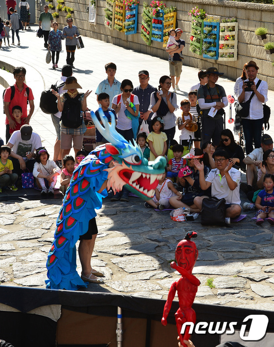 (서울=뉴스1) 이승배 기자 = 4일 오후 서울 청계천 광통교에서 시민들이 스토리텔링 전통인형극 '날아라 이시미'를 관람하고 있다. 이 공연은 오는 7월 16일까지 매주 주말 오후 …